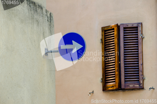 Image of One way sign with old window