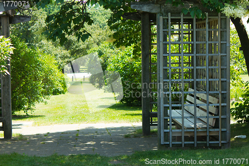 Image of Gazebo with bench in a garden