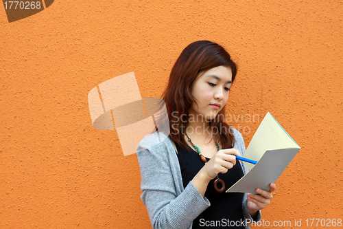 Image of Asian woman reading and studying