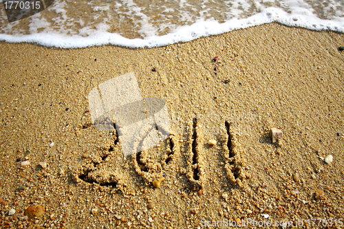 Image of 2011 written on sand