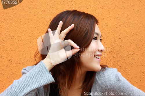 Image of Asian woman hearing voice