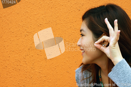 Image of Asian woman hearing voice