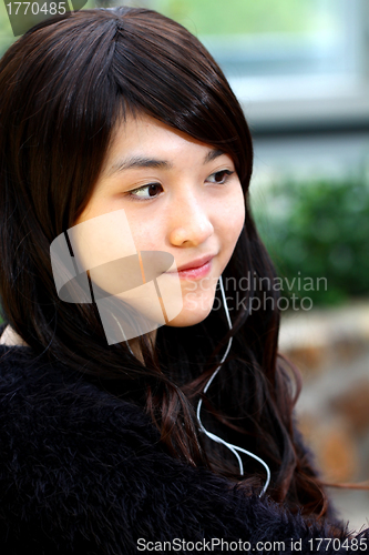 Image of Asian woman listening music