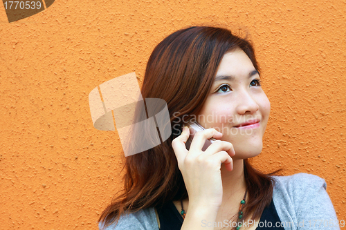 Image of Asian woman calling and talking on phone