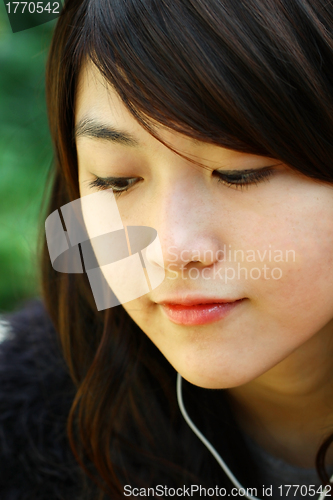 Image of Asian woman listening music