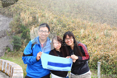 Image of Mountain hikers reach the hill top and showing their victory