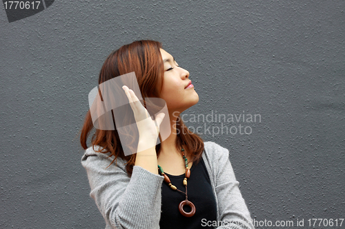 Image of Asian woman hearing voice