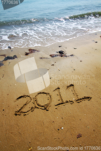 Image of 2011 written on sand