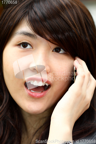 Image of Young asian woman talking on phone