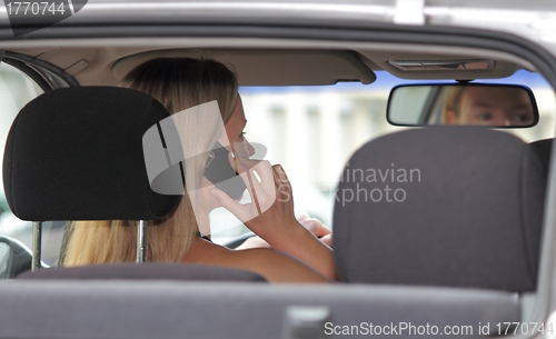 Image of Woman driver talking on her mobile phone