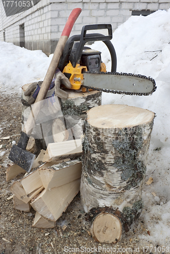 Image of Firewood and chainsaw with gloves