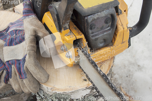Image of Firewood and a chainsaw with gloves