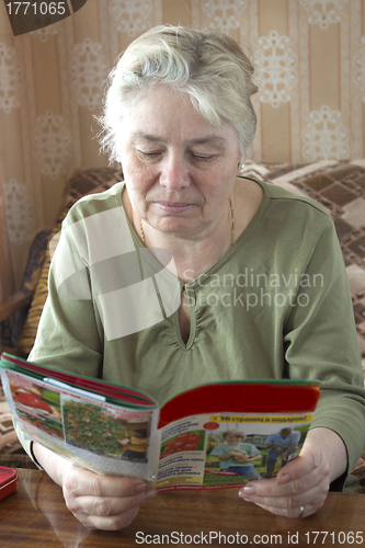 Image of An elderly woman reading a magazine