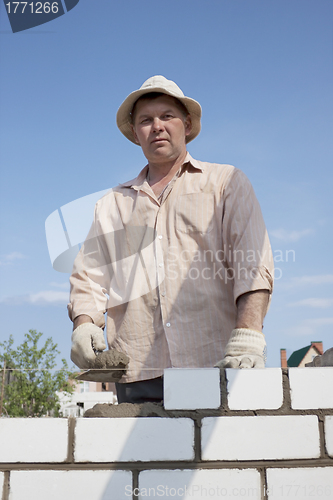 Image of Bricklayer builds a wall