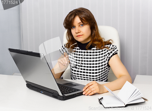 Image of Young businesswoman sitting at a desk