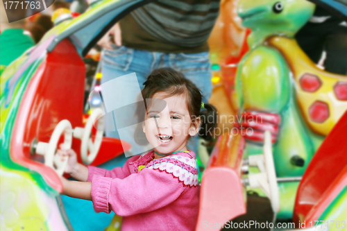 Image of little girl playing on carousel 