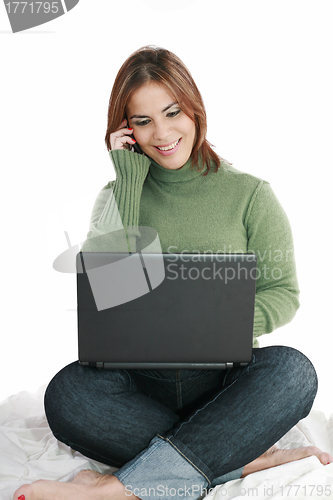Image of woman talking on mobile phone in front of laptop 