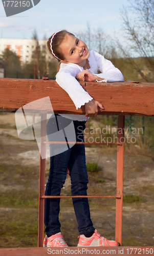 Image of A girl in jeans and sneakers to the playground