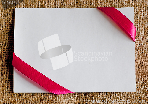 Image of gift card with ribbon on canvas textile