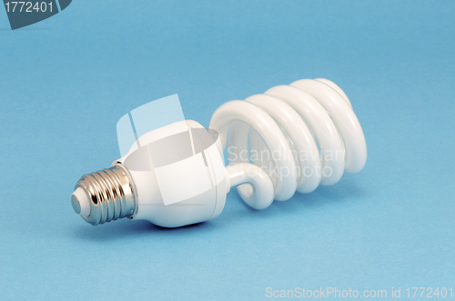 Image of Novel fluorescent light bulb on blue background 