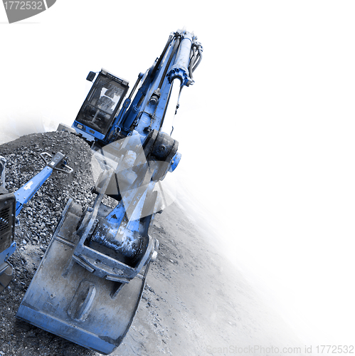 Image of backhoe digging small stones