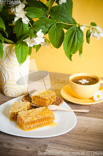 Image of Honeycomb with a cup of tea and a bouquet of blooming Jasmine