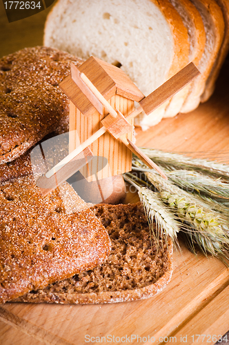 Image of sliced bread and wheat on the wooden table 