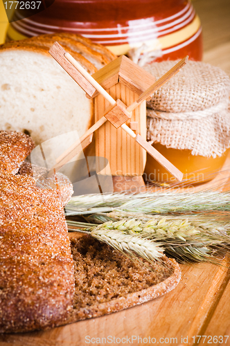 Image of sliced bread and wheat on the wooden table 