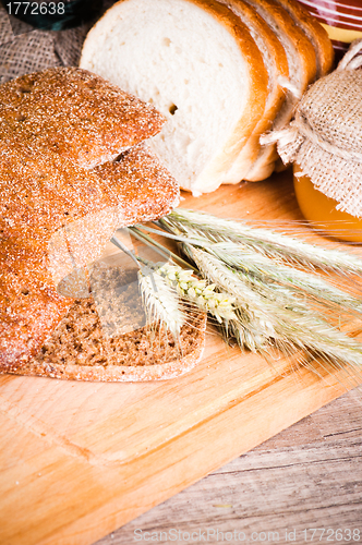 Image of sliced bread and wheat on the wooden table 