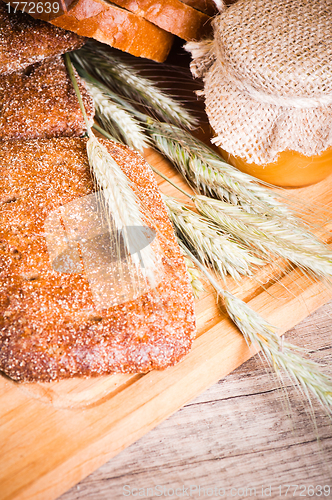 Image of sliced bread and wheat on the wooden table 