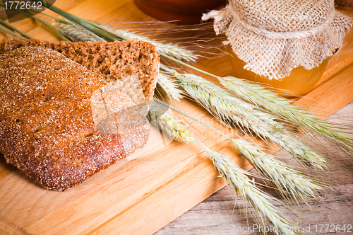 Image of sliced bread and wheat on the wooden table 