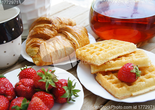Image of Tasty breakfast - tea, croissants, wafers with cream 