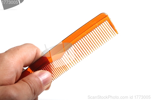 Image of plain plastic comb in a human hand