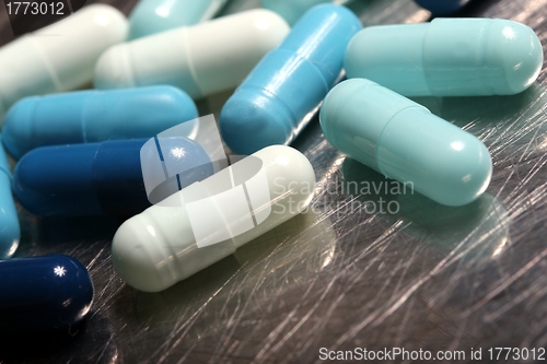 Image of colored medicinical capsules on a steel plate