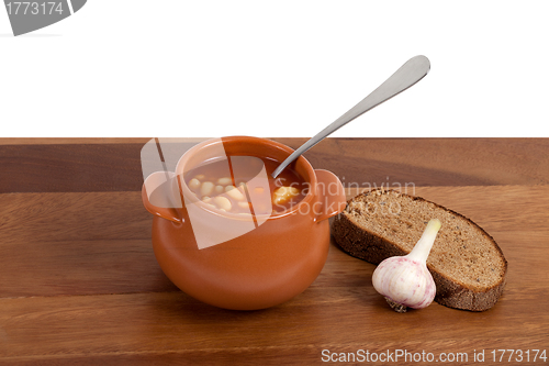 Image of Soup in ceramic pot with bread and garlic