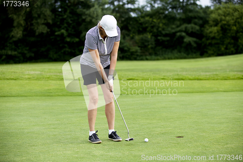 Image of woman is playing golf on course  summer