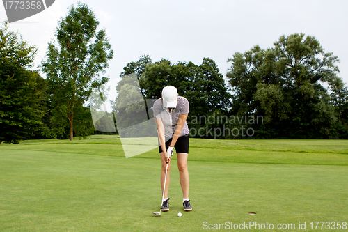 Image of woman is playing golf on course  summer