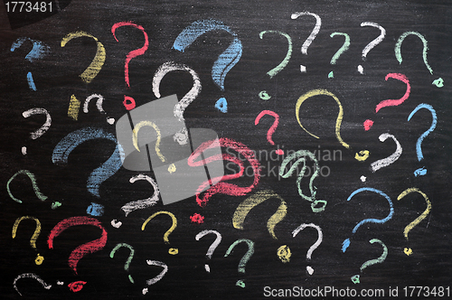 Image of Question marks on chalkboard. Decision, confusion, FAQ or other concept. Hand writing with chalk on school black board. 