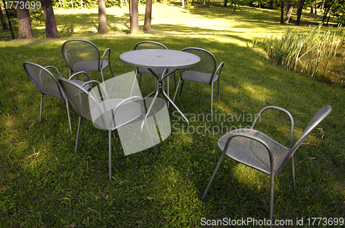 Image of Chairs made of metal steel on meadow grass 