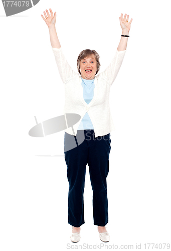 Image of Excited senior woman posing with raised arms