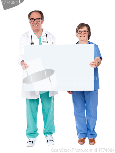 Image of Aged doctors displaying white billboard