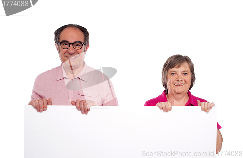 Image of Aged couple displaying blank billboard