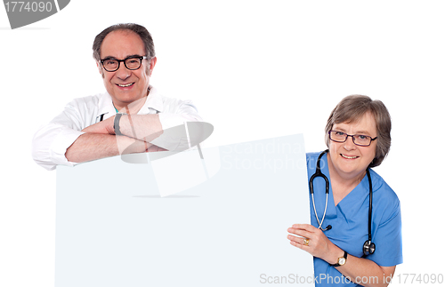 Image of Two matured doctors holding white banner ad