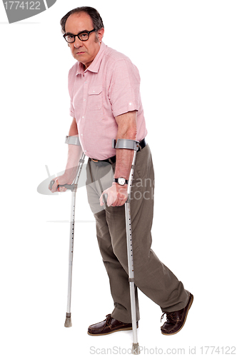 Image of Depressed senior male with two crutches