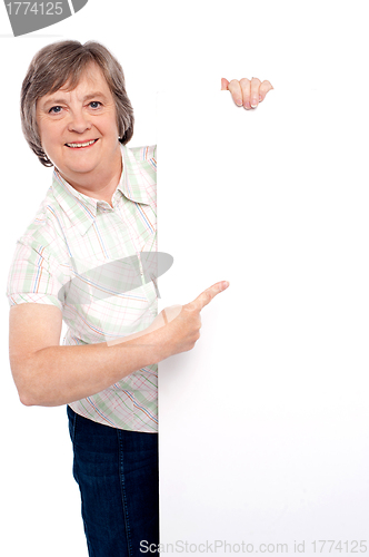 Image of Causal senior lady pointing towards placard