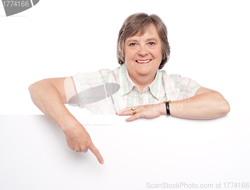 Image of Attractive old woman indicating towards billboard
