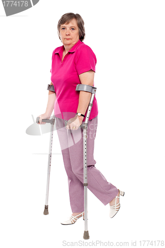 Image of Unhappy handicapped woman with crutches