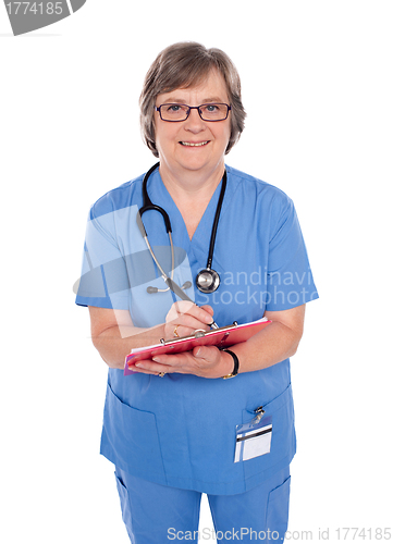 Image of Smiling matured doctor writing prescription