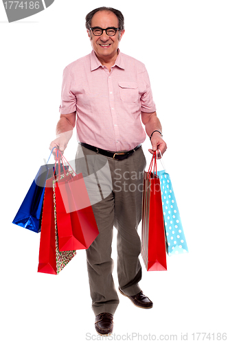 Image of Happy matured man carrying shopping bags