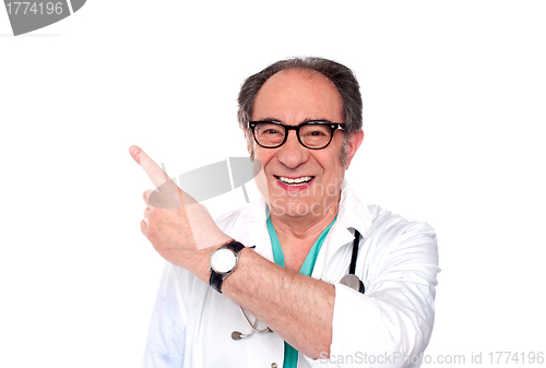 Image of Mature doctor pointing upwards and away